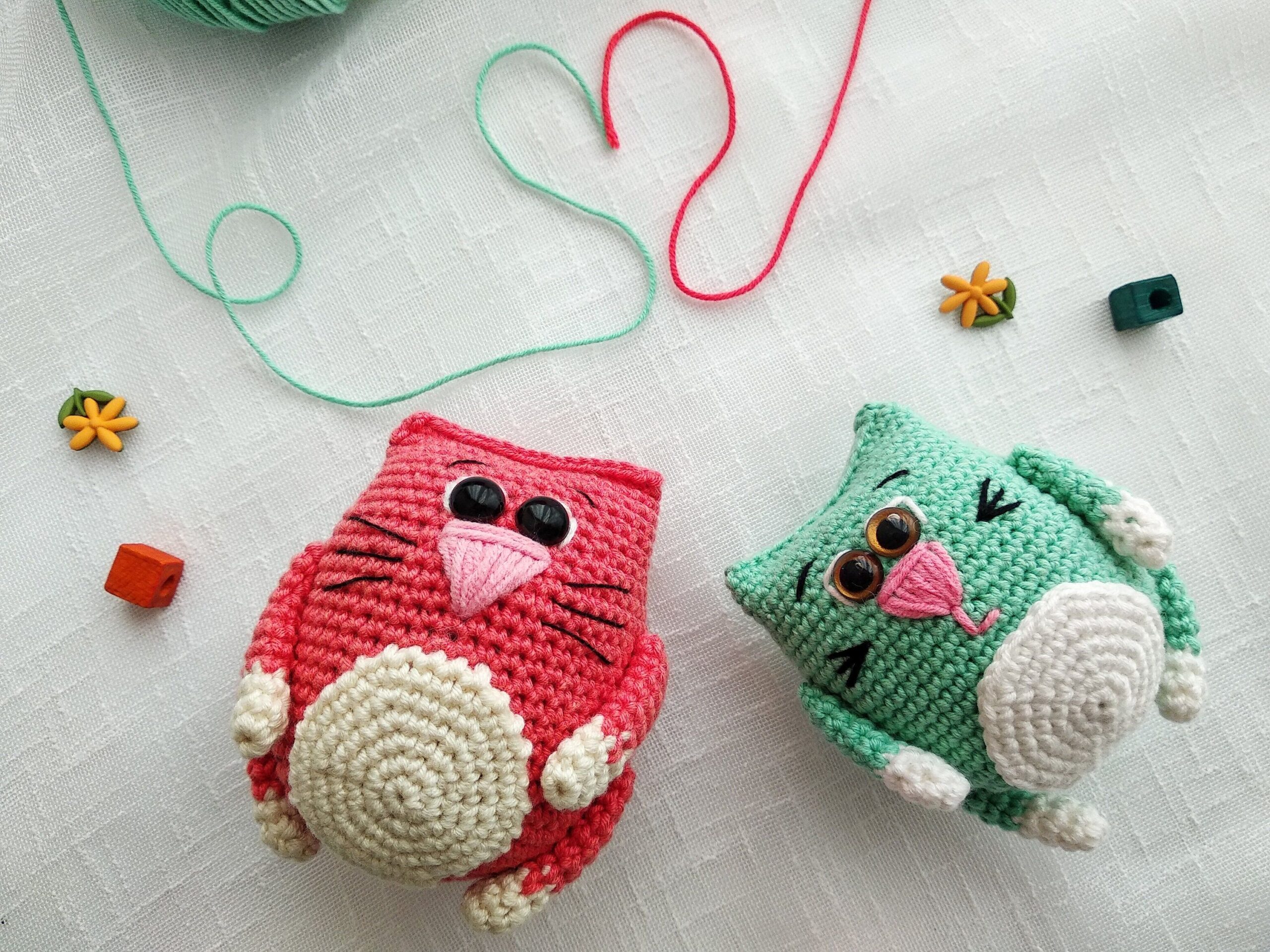 Cute crochet cat toys with yarn forming a heart on a white background.